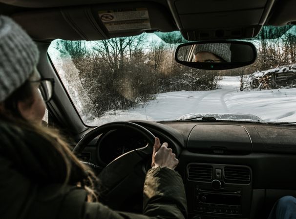 Woman driving car on snow field