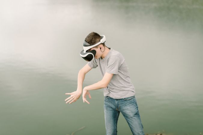 Young teenager with virtual reality glasses outdoors