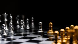 Chessboard perspective, silver versus golden pieces.