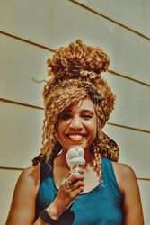 Happy Black female smiling with an ice cream cone in the sun, vertical