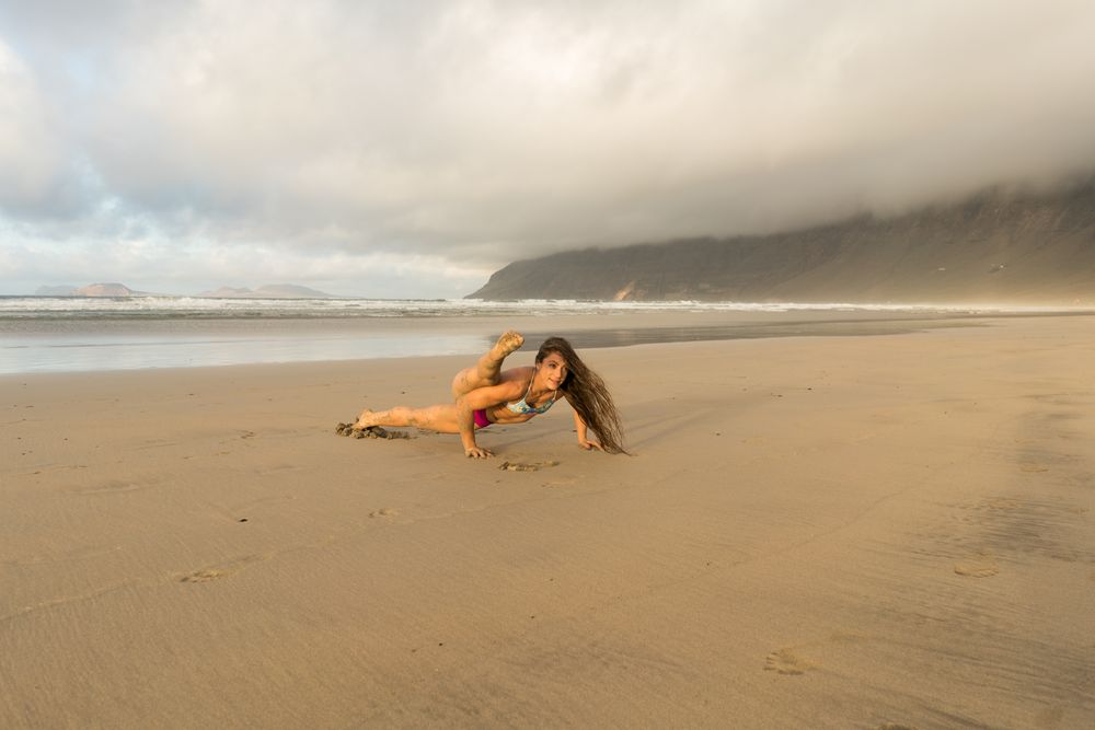 Woman doing handstand near sea