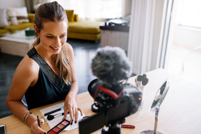 Female makeup artist working at home and recording video content