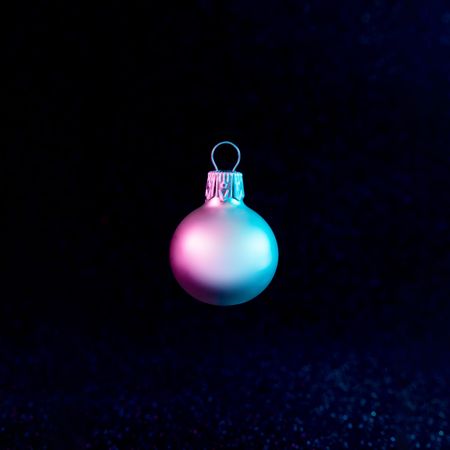 Christmas bauble in vivid neon colors on dark background