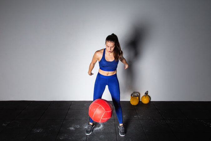 Woman lifting medicine ball in gym
