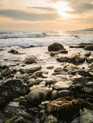 Stony seashore and waves at beautiful sunset