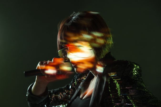 Stylish woman singing on stage