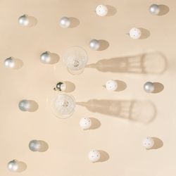 Top view of champagne glasses surrounded by Christmas baubles