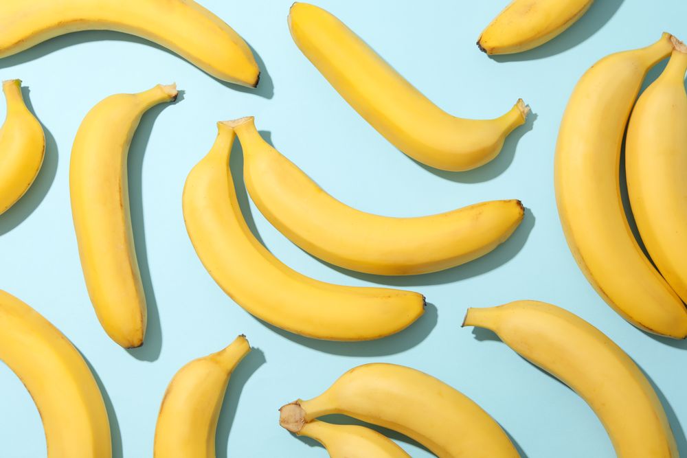 Banana clusters on blue background. Fresh fruit