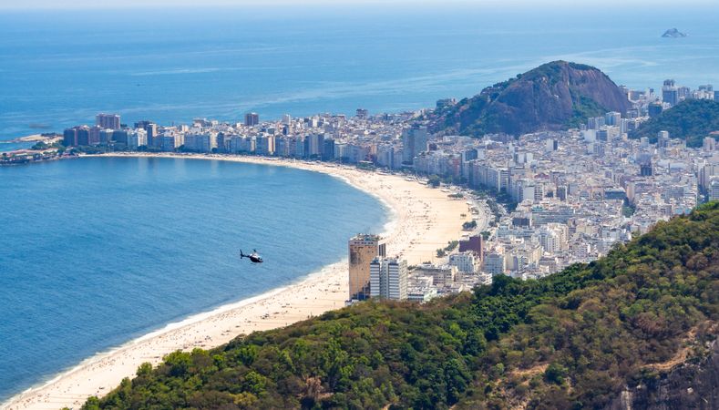 Helicopter over beach and coastal city