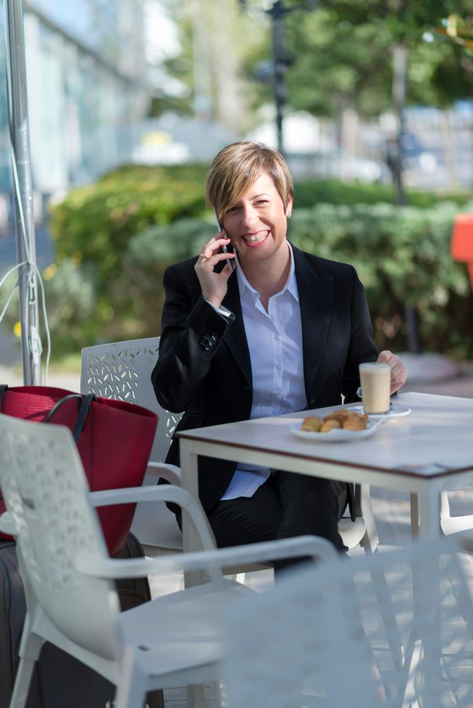 Female having lunch on table outside talking on phone