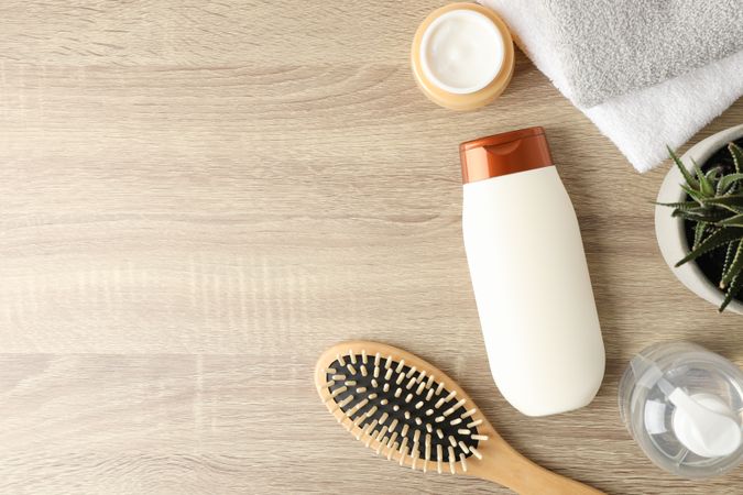 Composition with hair care products on wooden background, top view