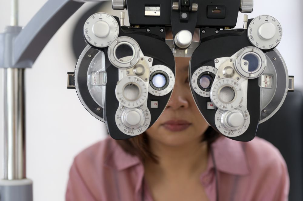 Young woman checking her eyesight and choosing glasses