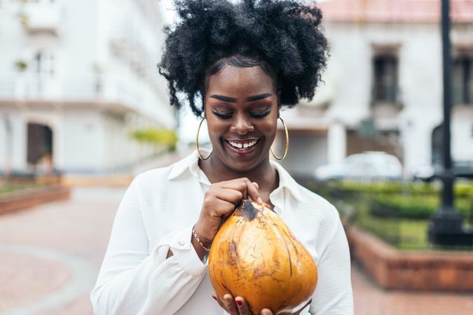 Latin American woman having fun in the city drinking coconuts