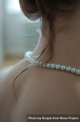 Close-up shot of back of woman wearing pearl necklace 423lxb