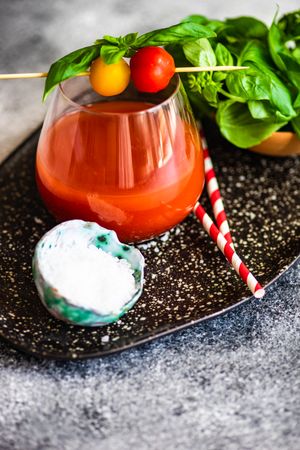Glass of fresh tomato juice with garnish and straws