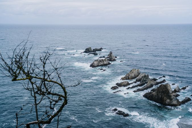Rocky peaks surrounded by foamy water in windy day