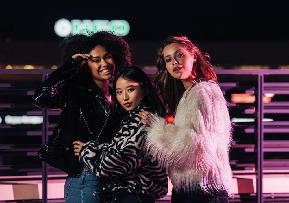 Multi-ethnic group of trendy women on terrace at night