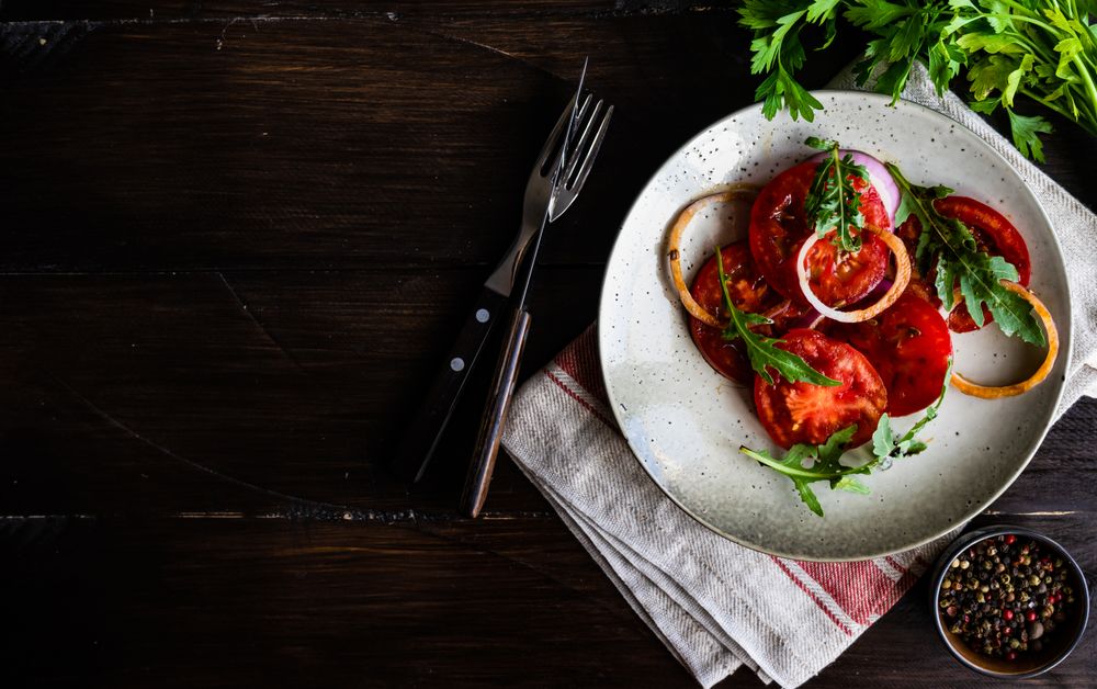 Top view of fresh tomato salad on counter with copy space