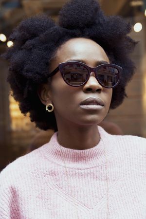 Portrait of woman in pink sweater wearing sunglasses