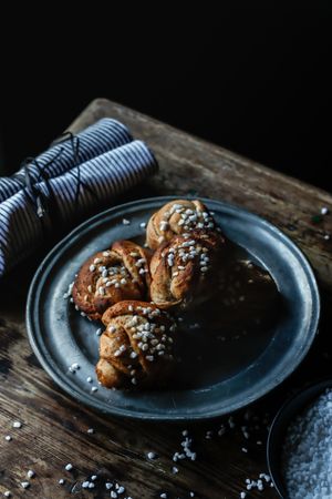 Plate of cardamom buns near towel and sugar
