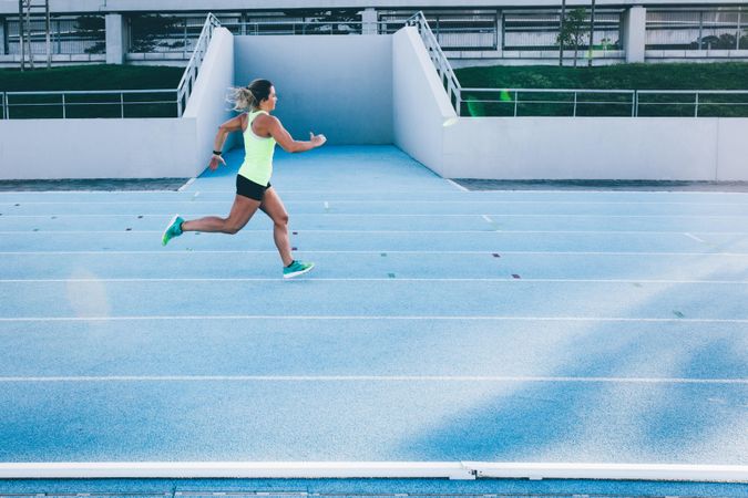 Young woman running on a track field