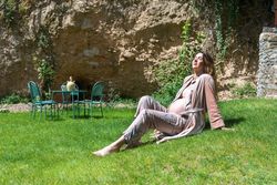 Pregnant woman enjoying the sun while sitting on the grass