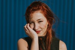 Smiling woman squinting in sun and enjoying weather