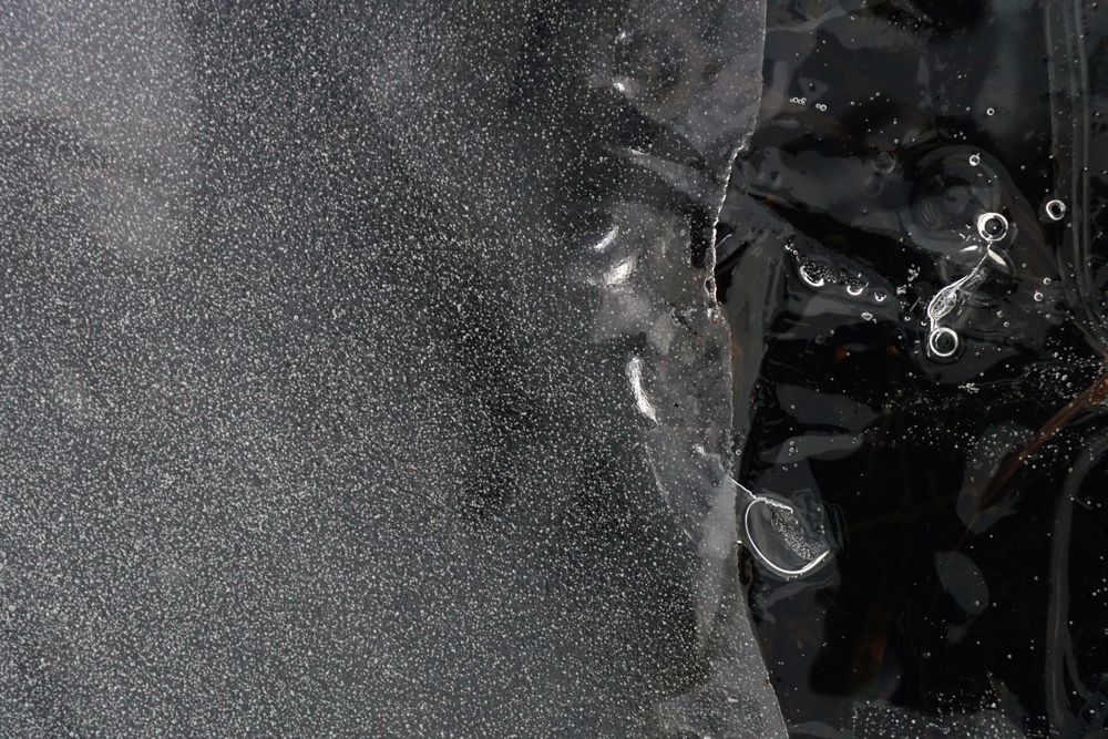 Fragment of thin ice on dark frozen river