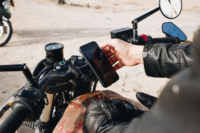 Man checking smartphone on motorcycle