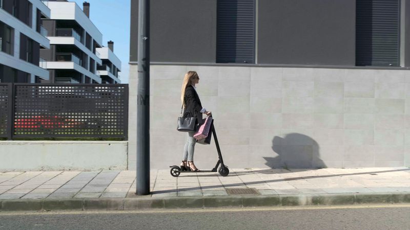 Woman coming home on electric scooter
