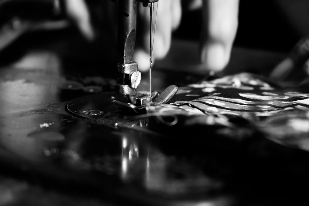 Close up of hands using sewing machine working on batik Indonesian fabric