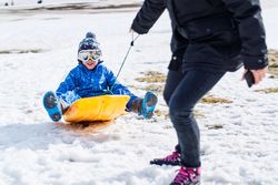 Mother and son playing with sleigh together