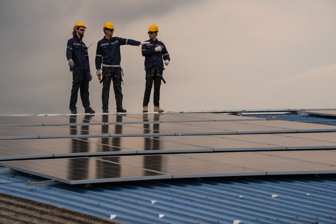 Engineer team checking solar cell  or photovoltaic cell installed on the roof of the factory. Technician worker repair or inspect the system. Industrial renewable energy concept