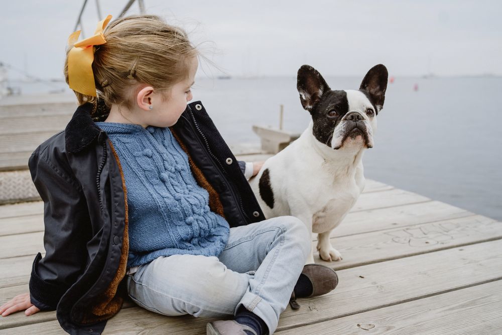 young girl with dog on pier