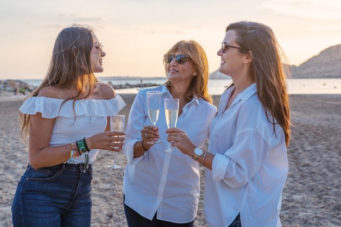 Happy family drinking wine on beach