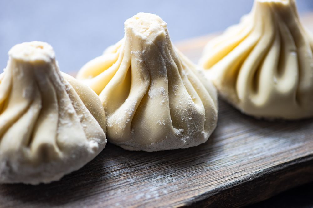 Close up of traditional Georgian khinkali dumplings served on wooden board