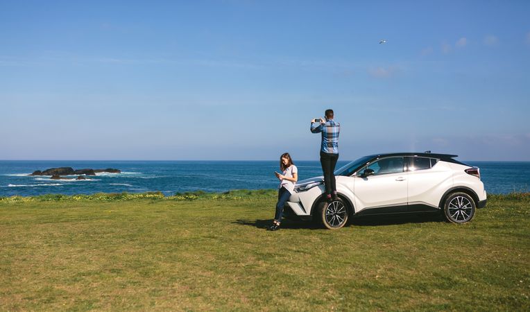 Couple traveling by car photographing the landscape