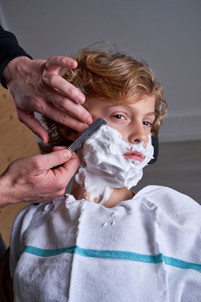 Boy shaving in a barbershop