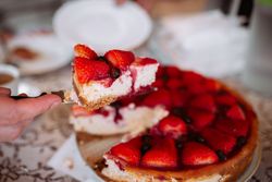woman hand cutting strawberry cake with knife
