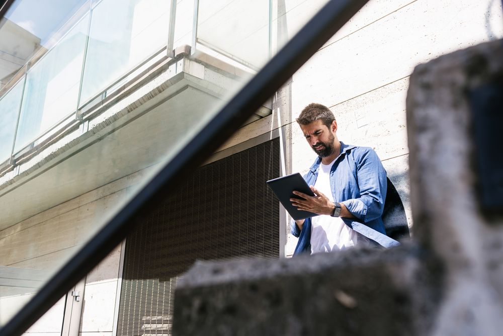 Man checking digital tablet outside