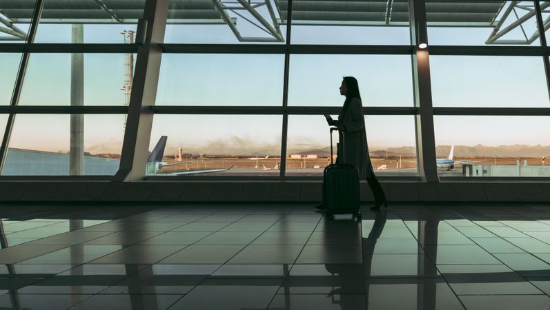 Female passenger waiting for flight at airport terminal