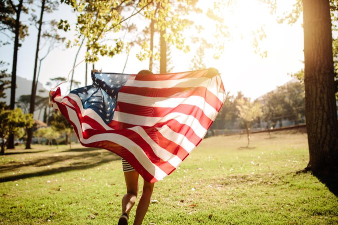 Woman running with American flag on a sunny day
