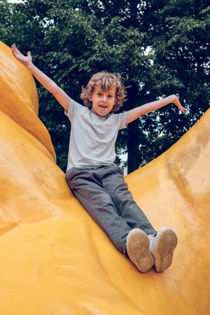 Cheerful boy sitting on yellow monument