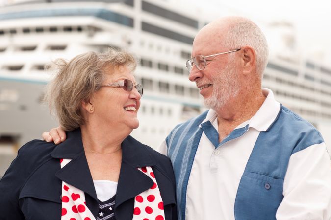 Older Couple On Shore in Front of Cruise Ship