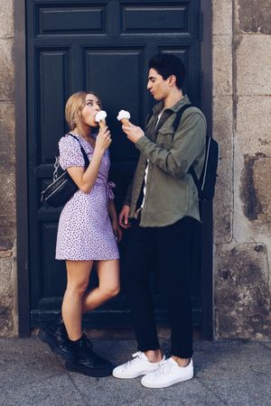 Happy couple feeding each other by ice cream