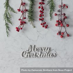 Christmas branches and berries on marble table with “Merry Christmas” 5zwQX4