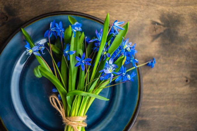 Top view of Easter table setting with lush scilla flowers on wooden table