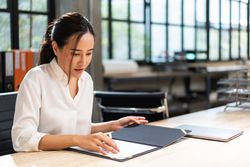 Woman reading through report at work