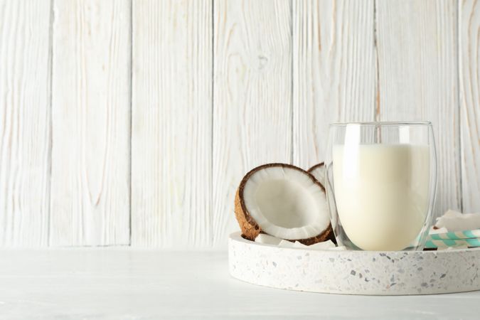 Tray with coconut and milk on wooden background. Tropical fruit