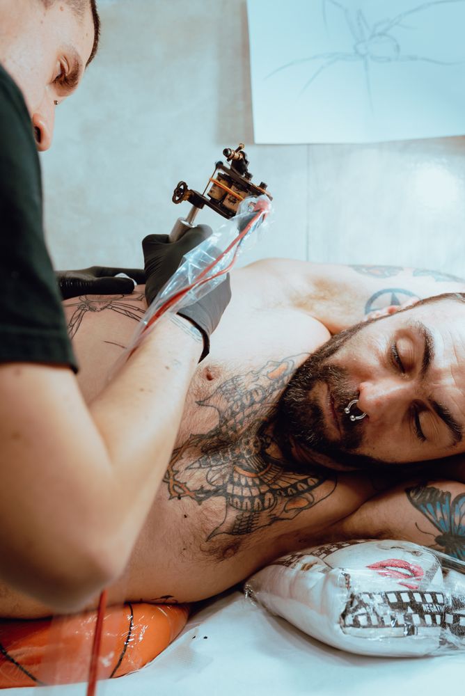 Man giving client a tattoo